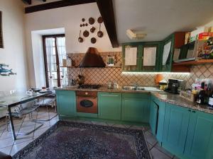 a kitchen with green cabinets and a table in it at Re di Quadri in Luino