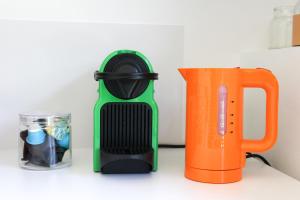 eine grüne und schwarze Saftpresse neben einer orangefarbenen Tasse. in der Unterkunft TinyHouse LE CONQUET in Le Conquet