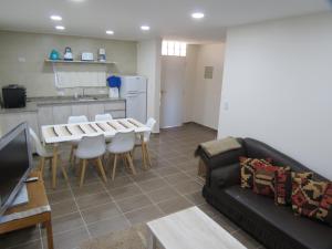 a living room with a couch and a table and a kitchen at Cabaña La Verdicchio Privacidad y exclusividad Tu lugar de descanso in Valle Grande