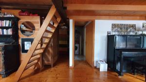 a staircase leading to a living room with a piano at Soffitta Loft panoramico in Fiera di Primiero