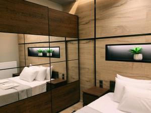 a bedroom with two beds and a mirrored wall at Luxury Townhouse Suite in Larisa