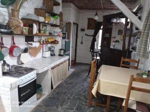 a kitchen with a table and a stove top oven at Chalé Alto in Soriano +28 photos