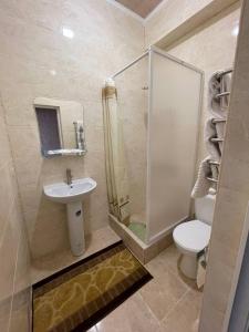 a bathroom with a shower and a toilet and a sink at Hotel Chicago in Umanʼ