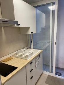 una cocina con encimera con un estante para la vajilla en Loft Cabanyal, en Valencia