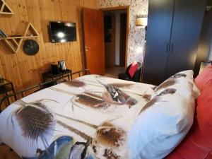 Les Sittelles - Tilff في Esneux: غرفة نوم عليها سرير وبطانية