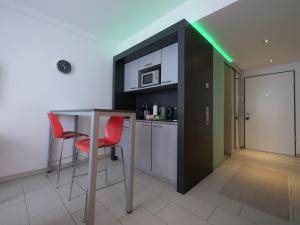 a kitchen with a table and two red chairs at Rooftop Apartment by Rabe - Parkplatz & free Netflix & Balkon in Karlsruhe