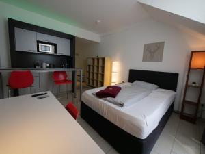 ein Hotelzimmer mit 2 Betten und einer Küche in der Unterkunft Rooftop Apartment by Rabe - Parkplatz & free Netflix & Balkon in Karlsruhe