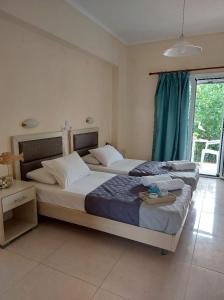 a bedroom with two beds and a window at Antonio Studios in Alikanas