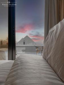 a bedroom with a bed and a view of a pyramid at Khan Duidar Inn - Pyramids View Rooftop in Cairo