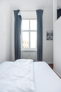 ein weißes Bett in einem Schlafzimmer mit einem Fenster in der Unterkunft Cozy and central City Apartment at the Belvedere in Wien