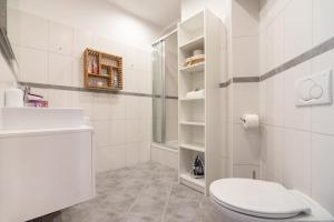 a white bathroom with a toilet and a sink at Cozy and central City Apartment at the Belvedere in Vienna