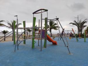 un parque infantil en la playa con un tobogán en Apartamento na Praia Grande en Praia Grande