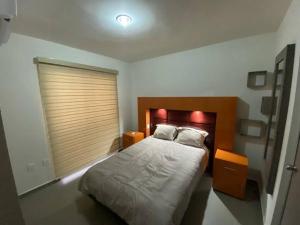 Tempat tidur dalam kamar di Departamento privado con alberca cerca de la playa