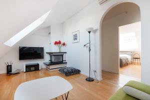 ein weißes Wohnzimmer mit einem Sofa und einem TV in der Unterkunft Vienna Roof Top Apartment with Terrace, Parking and AC in Wien