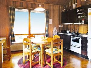 eine Küche mit einem Holztisch, Stühlen und einem Herd in der Unterkunft Holiday home HOLMSJÖ II in Troxhult