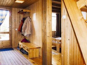 Zimmer mit einer Holzwand mit einer Bank in der Unterkunft Holiday home HOLMSJÖ II in Troxhult