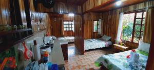 a room with a bedroom with two beds and a kitchen at Jardin entre Montañas in Bijagua