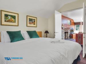 a bedroom with a large white bed with green pillows at Aspect 2A in Thredbo
