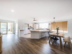 
a kitchen with a table, chairs and a refrigerator at 31 Melville Street in Iluka
