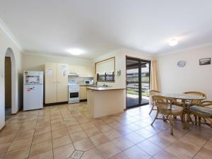
a kitchen with a table and a refrigerator at Armorel at Iluka in Iluka
