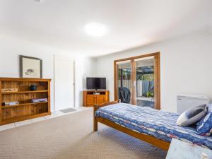 a bedroom with a bed and a tv in it at Bundjalung and Baby Bundjalung in Iluka