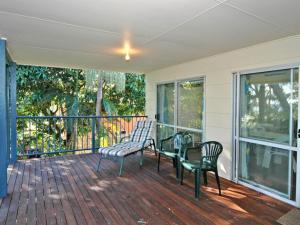 a screened porch with two chairs and a glass table at Bayview at Iluka in Iluka