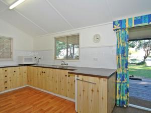 a kitchen with wooden cabinets and a large window at Bayview at Iluka in Iluka