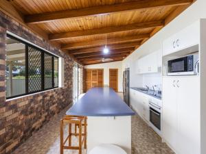 a kitchen with white cabinets and a blue counter top at Crowes Nest in Iluka