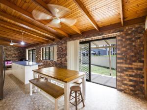 a kitchen with a table and a ceiling fan at Crowes Nest in Iluka