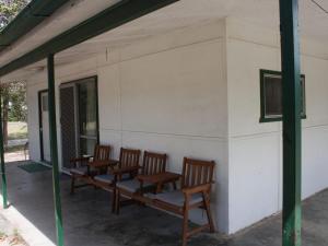 a group of chairs sitting on the porch of a building at Luka Land in Iluka +2 photos