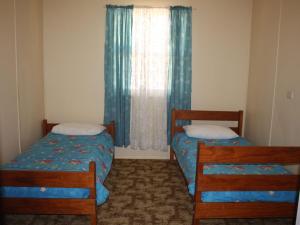 two beds in a small room with a window at Luka Land in Iluka