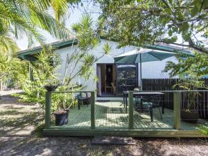 a house with a deck with a table and an umbrella at Ohana at Iluka in Iluka