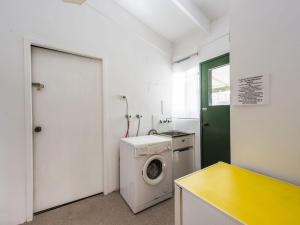a laundry room with a washing machine and a washer at Ohana at Iluka in Iluka