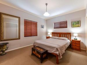 a bedroom with a bed and two windows at Rhijac at Iluka in Iluka