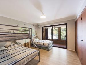 two bunk beds in a room with a window at Ripples on the Bay in Iluka