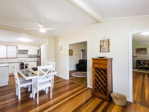 a dining room and kitchen with a table and chairs at Salt Water Cottage in Iluka