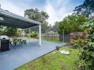 a covered patio with a picnic table and a grill at Salt Water Cottage in Iluka