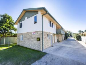 a large brick building with a driveway at Sandy Feet in Iluka