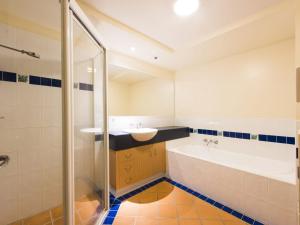 a bathroom with a tub and a sink and a bath tubermott at Riverview Apartments 2 3 Building 2 Unit 3 in Iluka