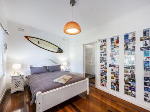 Schlafzimmer mit einem Bett und einem Surfbrett an der Wand in der Unterkunft The Beach Shack on Spenser in Iluka