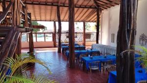 um restaurante com mesas azuis e cadeiras num quarto em Mangue Seco Fantasias do Agreste em Mangue Sêco