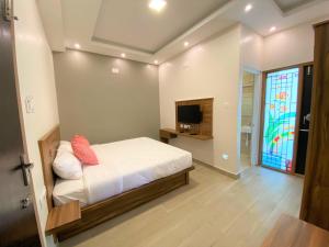 a bedroom with a bed and a tv in it at Avalon Stays in Ooty