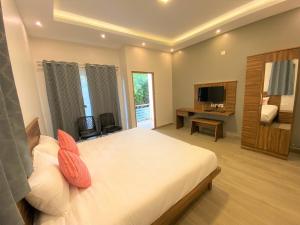 a bedroom with a large bed and a television at Avalon Stays in Ooty