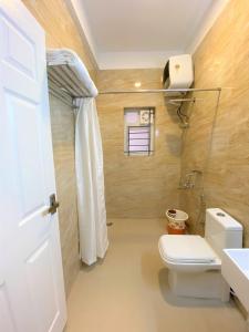 a bathroom with a white toilet and a sink at Avalon Stays in Ooty
