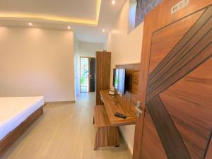 a bedroom with a bed and a wooden door at Avalon Stays in Ooty