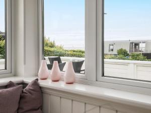 a room with three pink vases sitting on a window sill at 2 person holiday home in Esbjerg V in Esbjerg