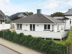 a white house with a black roof on a street at 2 person holiday home in Esbjerg V in Esbjerg