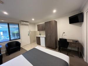 1 dormitorio con cama, escritorio y ordenador en Ryley Motor Inn, en Wangaratta