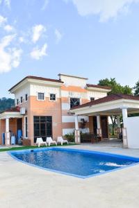 a villa with a swimming pool in front of a house at SHA GATHERING ALOR GAJAH BUNGALOW, A FAMOSA MELAKA in Melaka