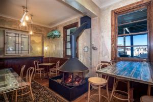 a fireplace in a restaurant with a table and chairs at Metropolitan Hotel in Orange
